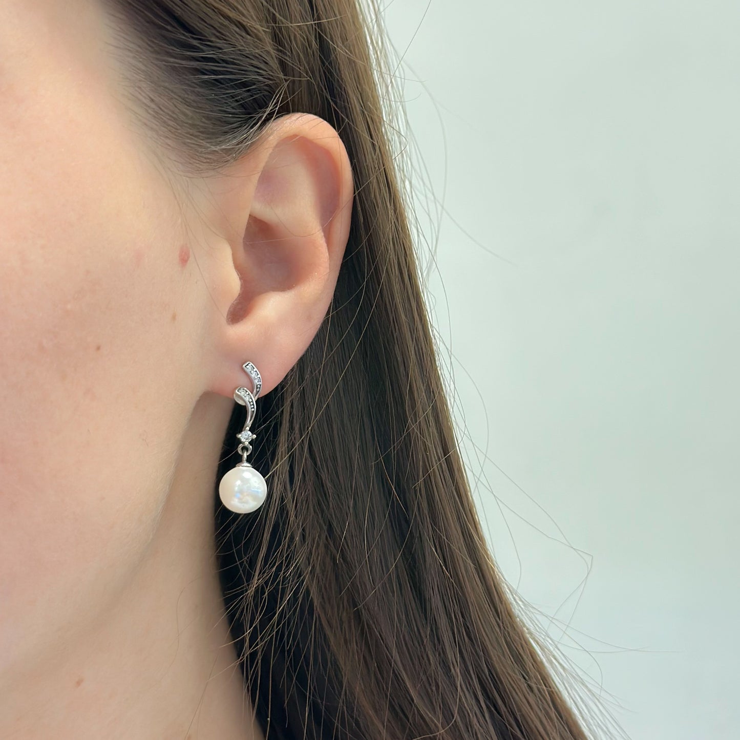 Sidabriniai rodžiuoti kabantys auskarai su cirkoniu ir perlu