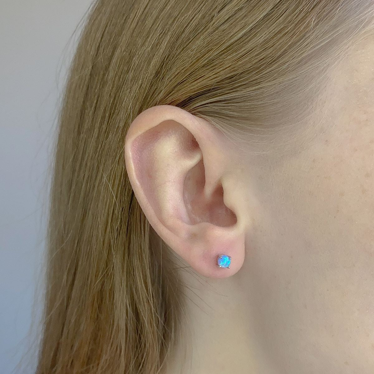 Sidabriniai rodžiuoti auskarai su žydru sintetiniu opalu