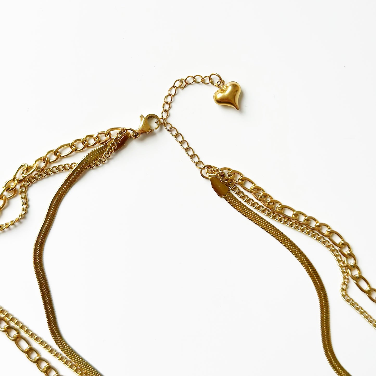 Auksuota triguba koljė su skirtingų pynimų grandinėlėmis ir širdele